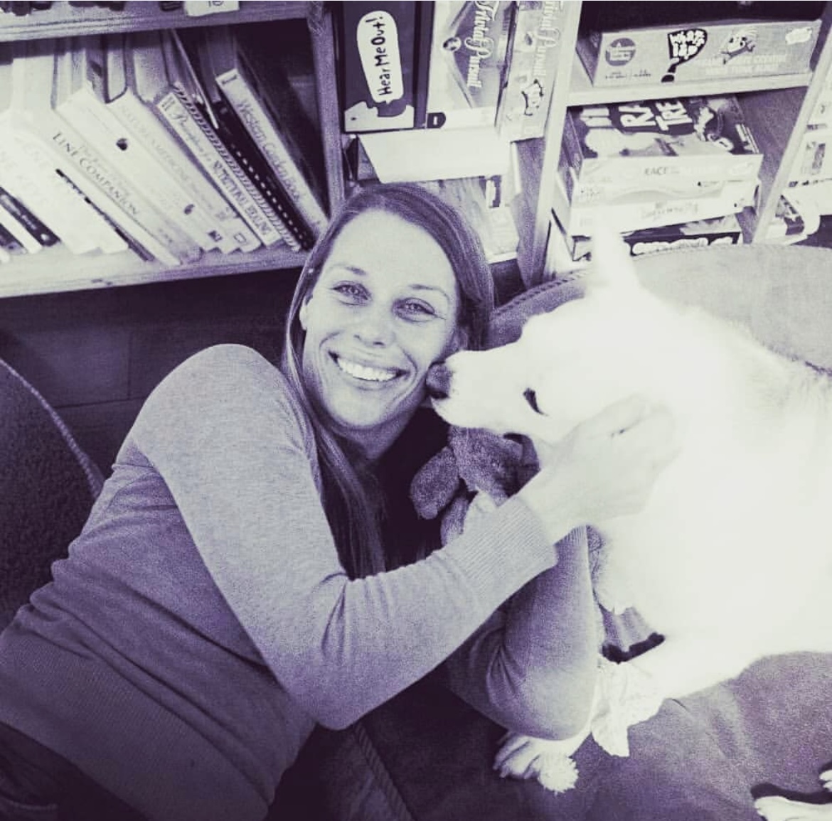 Southern California Pet Sitting . Woman hugging white dog in a retro indoor setting (black and white photo) – Nostalgic black-and-white image of a pet sitter embracing a white dog in a loving cuddle.