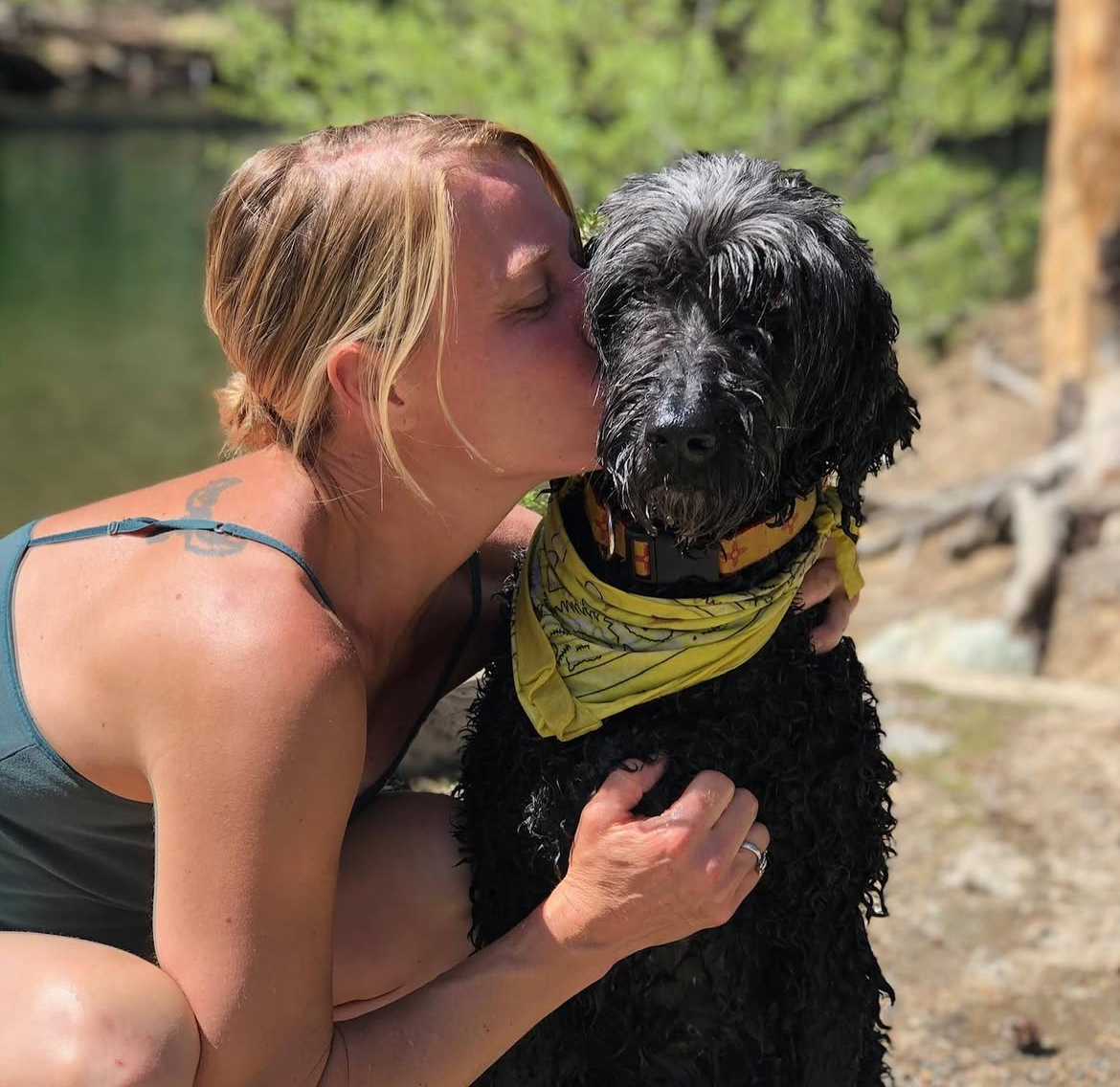 Heartfelt moment between Aeray and black poodle mix – deep bond in nature. Southern California Pet Sitting 